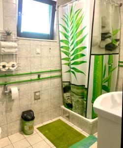 a bathroom with a shower with a green plant on the shower curtain at VIP Rooms Foča, Accommodation Foca, Foca Rooms in Foča