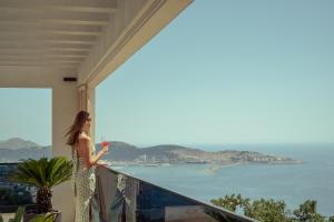 una mujer parada en un balcón con una copa de vino en THE VIEW Premium Villas en Bar