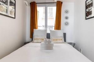 Un dormitorio con una cama blanca con un osito de peluche. en Grands Boulevards 22 : Appartement Cosy 1BR-4P, en París