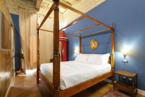 1 dormitorio con cama con dosel en una habitación azul en Prestige Boutique Aparthotel - Montenapoleone en Milán