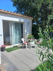 a patio with a table and chairs in front of a house at Air de vacances in Clermont-lʼHérault
