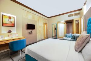 una camera con letto, scrivania e divano di Hotel Pal Heights a Bhubaneshwar