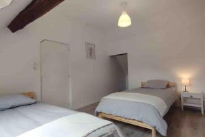 a bedroom with two beds in a room at gîte Maison entière 6 personnes in Saint-Julien-de-Chédon