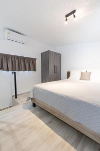 um quarto branco com uma cama grande e uma mesa em Pagani Green - Luxury Maisonette B3 em Kalamata