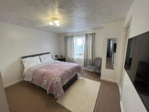 a bedroom with a bed and a television in it at Corby Guest House in Corby