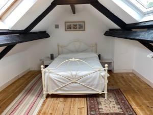 a bedroom with a white bed in a attic at The Soap Barn in Manorbier
