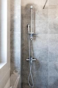 a shower with a shower head in a bathroom at Pagani Green - Luxury Maisonette B3 in Kalamata