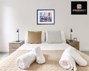 a bedroom with a white bed with white towels on it at Luxe Modern Apartment By Your Perfect Stay Short Lets Birmingham in Birmingham