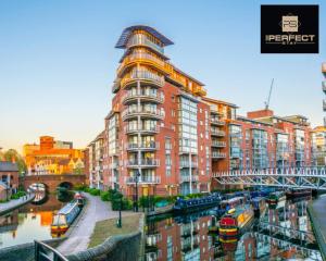a large red building next to a river with boats at Luxe Modern Apartment By Your Perfect Stay Short Lets Birmingham in Birmingham