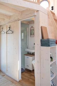 a tiny house with a bathroom and a sink at Besonderer Urlaub auf Hausboot TYSTNADEN in Hamburg