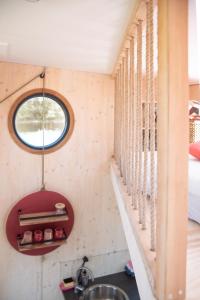 ein Bad mit einem Waschbecken und einem Fenster in der Unterkunft Besonderer Urlaub auf Hausboot TYSTNADEN in Hamburg