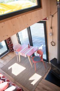 einen Tisch und Stühle in einem Zimmer mit einem großen Fenster in der Unterkunft Besonderer Urlaub auf Hausboot TYSTNADEN in Hamburg