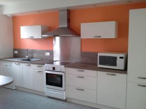eine Küche mit weißen Schränken und einer Mikrowelle in der Unterkunft Location Duverger in Vendôme