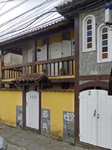 un edificio con puertas blancas y graffiti en él en Casa Exclusiva Centro & Praia, en Búzios