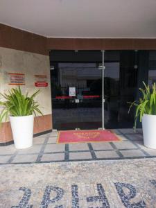two potted plants in front of a building at Farol Barra Flat maravilhoso 2 quartos Barra Salvador in Salvador