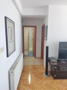 een kamer met een hal met een televisie en een bureau bij Maja Apartment in Skopje