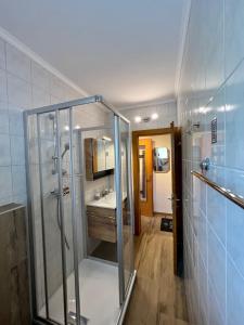 a bathroom with a glass shower and a sink at Gästehaus Wallner in Presseggen