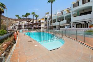 una piscina frente a un edificio en Oceanview en Mogán