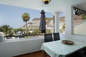 balcón con mesa y vistas a la playa en Oceanview en Mogán