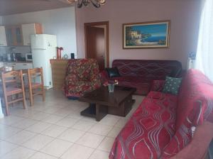 uma sala de estar com um sofá e uma mesa em Depys' View em Quios
