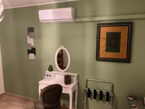Zimmer mit einem Waschtisch, einem Spiegel und einem Waschbecken in der Unterkunft Number9 - now with air conditioned rooms in Carlipa