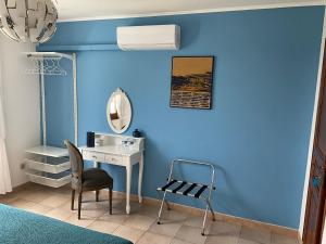 ein blaues Zimmer mit einem Schreibtisch und einem Stuhl in der Unterkunft Number9 - now with air conditioned rooms in Carlipa