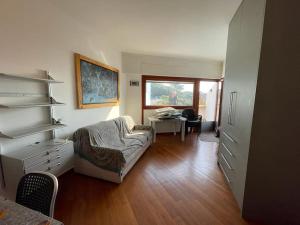 ein Wohnzimmer mit einem Sofa, einem Tisch und einem Schreibtisch in der Unterkunft Lido di Chioma - vista mare in Chioma