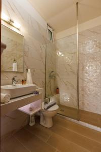 a bathroom with a toilet and a sink and a shower at Panorama Hotel Apartments & Suites by Estia in Stalís