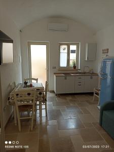 sala de estar con mesa y cocina en Villa Confalonieri, en Tricase