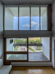 duże szklane okno w pokoju z kanapą w obiekcie Le Corbusier Expérience w mieście Firminy