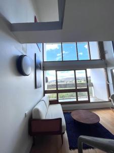 un soggiorno con divano bianco e una grande finestra di Le Corbusier Expérience a Firminy