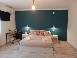 a bedroom with a white bed and a blue wall at LaCasaDiLucia SELF CHECK-IN in San Vito Chietino