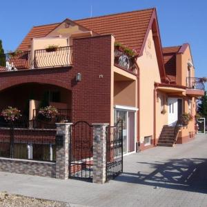 - un bâtiment en briques avec un portail et un balcon dans l'établissement Korona Home, à Sárvár