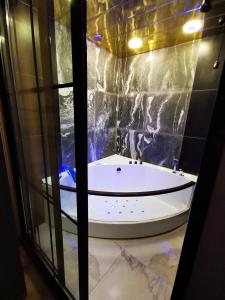 a bath tub in a room with a glass wall at City Center Cozy 3Bedroom Apartment with Unique Design and Hot Tub , 2Bathroom, Middle of Center, By Republic Square in Yerevan +43 photos
