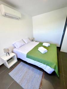 a bedroom with a bed with a green blanket at Casa Amarela - Mondim de Basto in Mondim de Basto