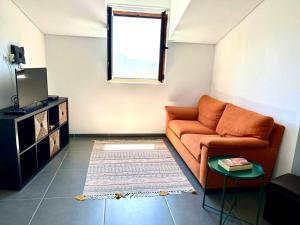 ein Wohnzimmer mit einem Sofa und einem Fenster in der Unterkunft Casa Amarela - Mondim de Basto in Mondim de Basto