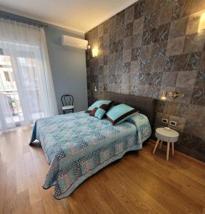 1 dormitorio con cama y pared de piedra en BariBello Apartment - 3 Bedrooms 3 Bathrooms - Bari Central Station, en Bari