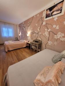 um quarto com duas camas e uma parede com flores em BariBello Apartment - 3 Bedrooms 3 Bathrooms - Bari Central Station em Bari