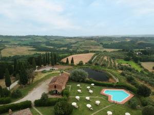 an aerial view of a farm with a house and a pool at Santo Pietro Resort in San Gimignano