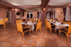 a restaurant with tables and chairs in a room at Pensiunea Floare de Colt in Băile Herculane