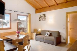 ein Wohnzimmer mit einem Sofa und einem Tisch in der Unterkunft Aurora Moarhof Natur Apartments in Lajen