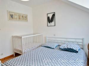 ein Schlafzimmer mit einem Kinderbett und zwei Kissen auf einem Bett in der Unterkunft Gîte familial pour 6 pers en campagne in Bouère