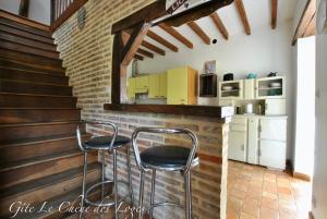 eine Küche mit zwei Hockern an einer Bar in einem Haus in der Unterkunft Gîte familial pour 6 pers en campagne in Bouère