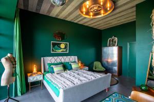 a bedroom with green walls and a bed and a table at Chy conary in Carbis Bay