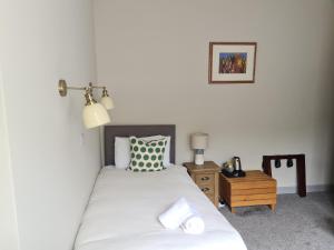 a bedroom with a bed and a table with a lamp at The Dornie in Dornie