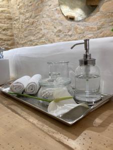 a tray with towels and a glass bottle on a sink at No12 in Mansle
