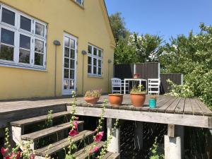 una casa con piante in vaso su un ponte di legno di Solfryd i Ollerup a Ollerup