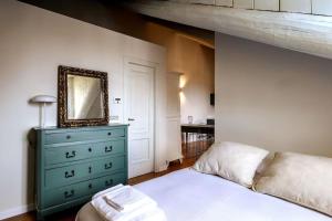 um quarto com uma cama e uma cómoda com um espelho em Art Heaven-Suite Graneri in Torino Centro em Turim