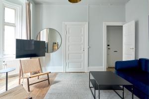un salon avec un canapé bleu et un miroir dans l'établissement Perfect for Friends & Families 2 Bedroom Apartment in CPH, à Copenhague