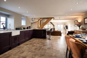 a kitchen and living room with a counter and a table at The Granary at Rothley East Shield in Longwitton